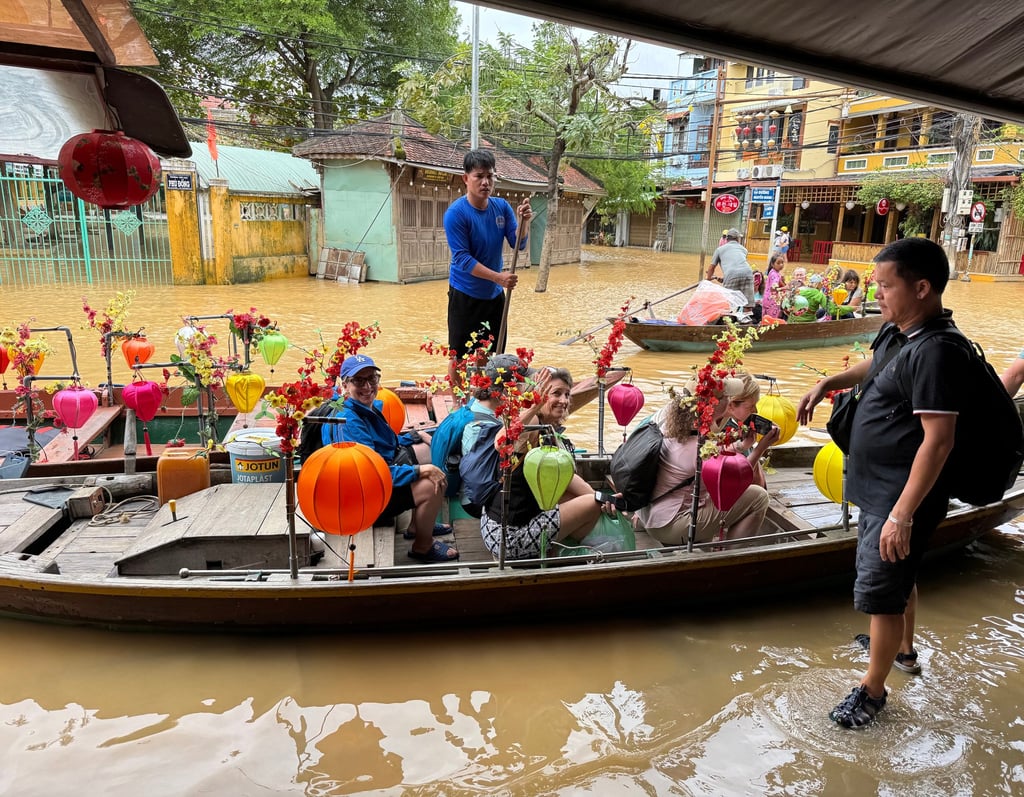 Tour leader Mr Nam (right) loads the AdventureWomen group into boats he hired to transport them across the flooded streets of Hoi An, Vietnam. Photo: TNS