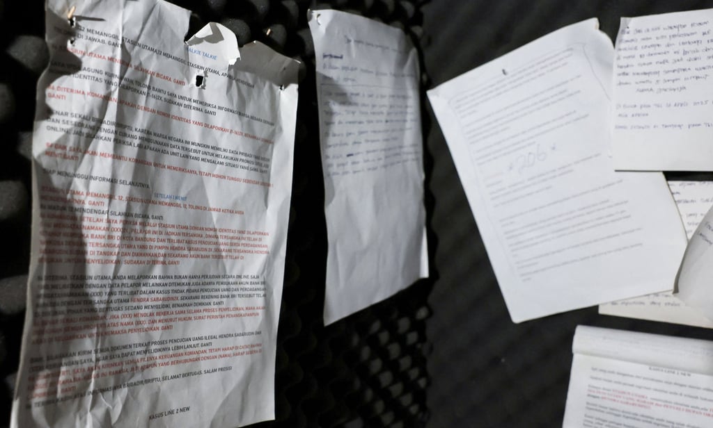 Scripts for scam dialogues are pasted inside a booth lined with acoustic foam that was used to make scam calls to victims. Photo: Reuters