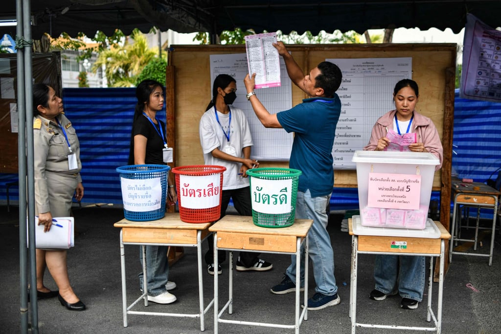 An official holds up votes in Thailand’s general election as they are counted at a polling station in Bangkok on Sunday. Photo: AFP