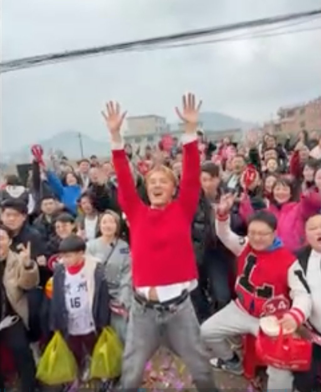 Melompat kegirangan: Wu yang mengenakan atasan merah, di tengah depan, telah menerima pujian atas karya amalnya. Foto: CCTV