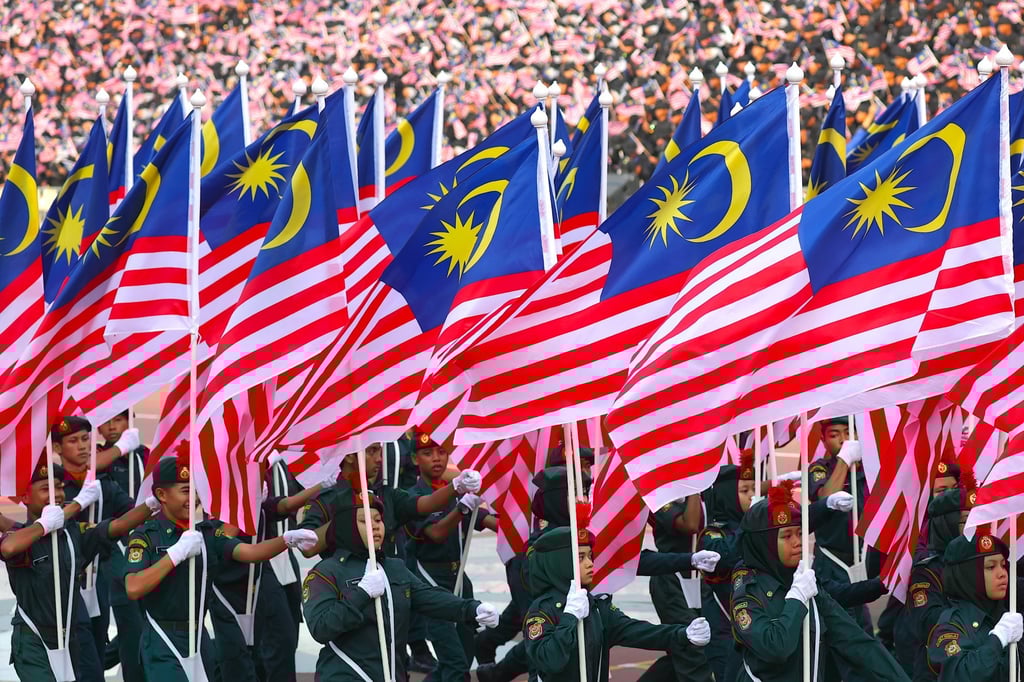 Participants hold the national flag during Independence Day celebrations in Putrajaya, Malaysia, on August 31, 2025. Photo: EPA