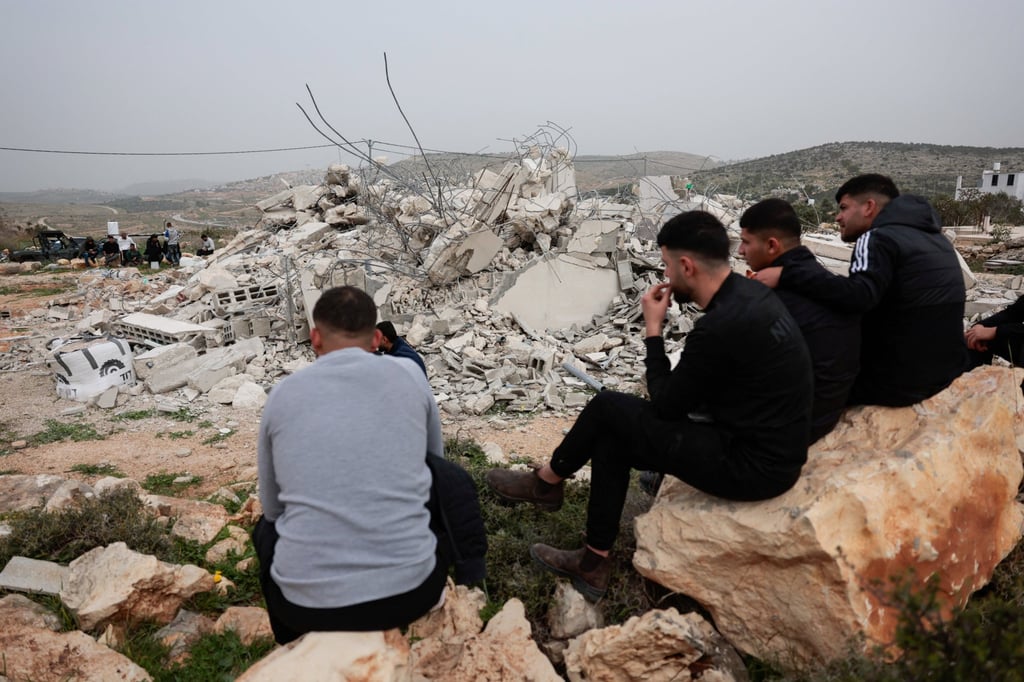 Palestinian men sit near the rubble of a building demolished by the Israeli military near Ramallah in the Israeli-occupied West Bank on Monday. Photo: Reuters