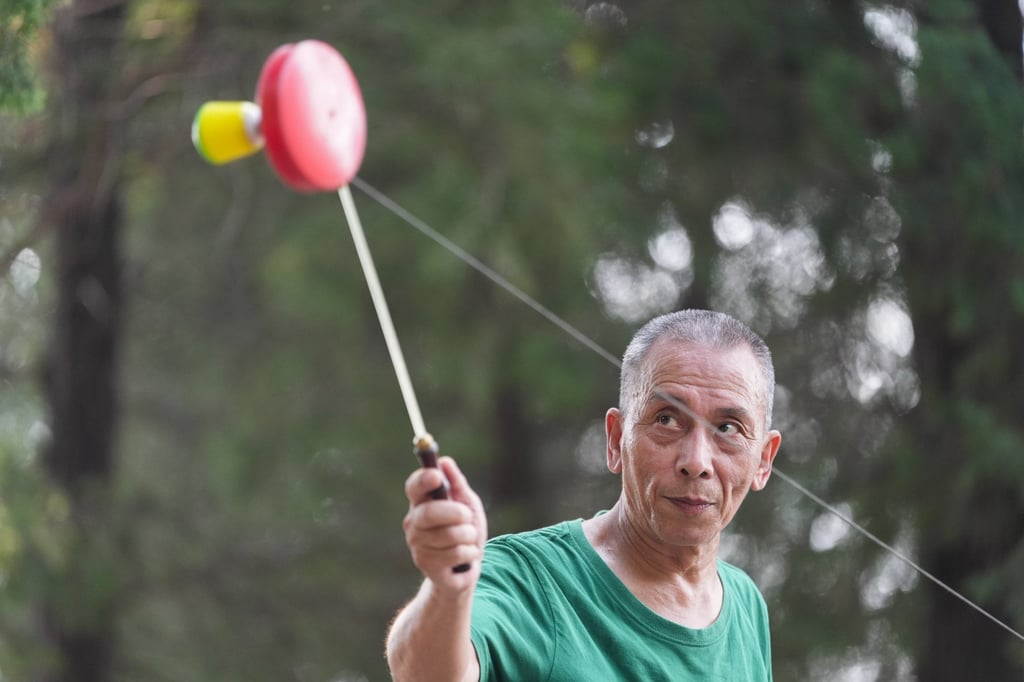 Seorang pria lanjut usia memainkan Diabolo, yang juga dikenal sebagai yo-yo Tiongkok, di Beijing. Negara ini sedang bergulat dengan masalah populasi yang menua. Eugene Lee