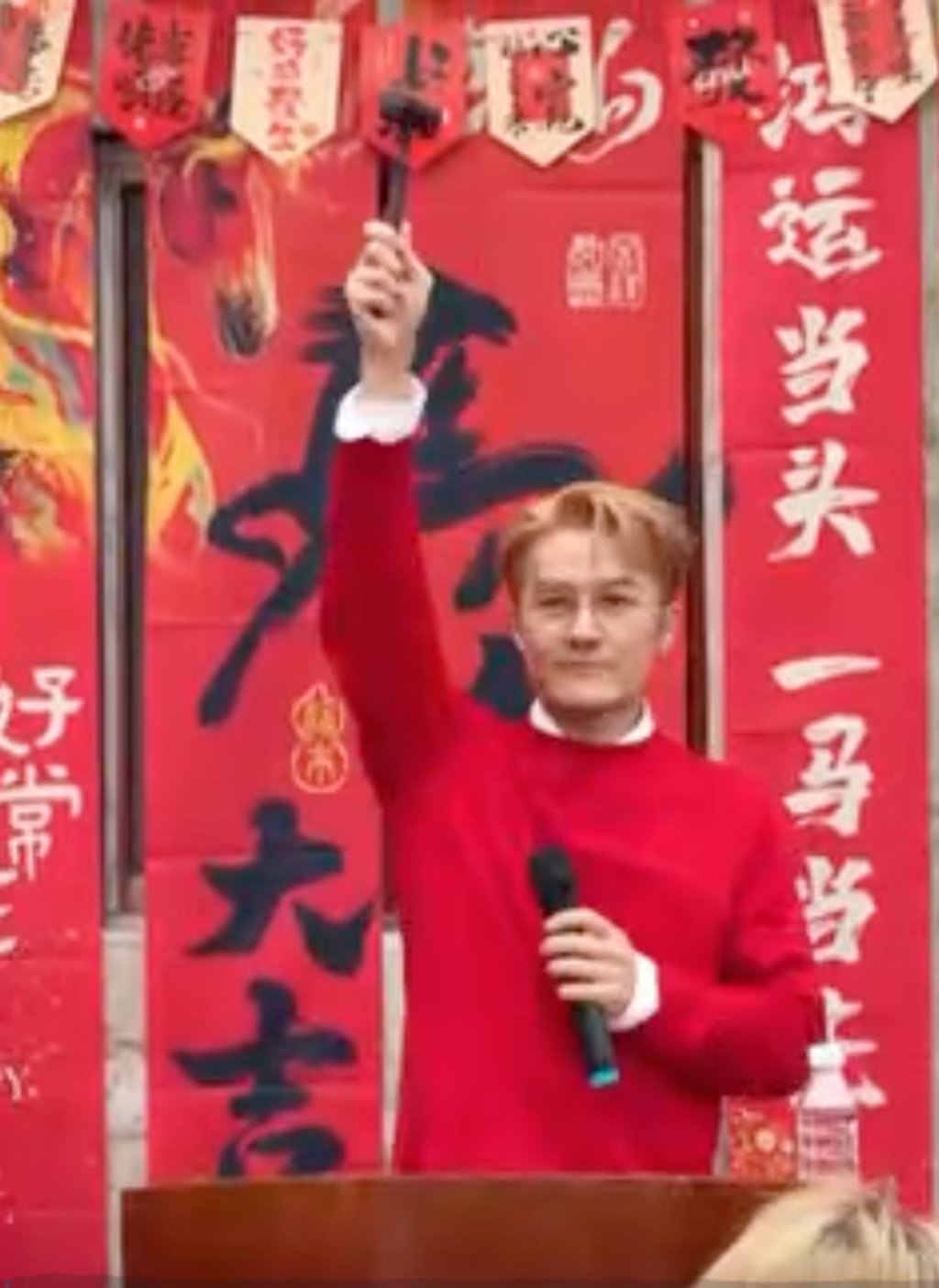 Kenji Wu prepares to bring down the hammer at an auction for farmers’ produce. Photo: CCTV