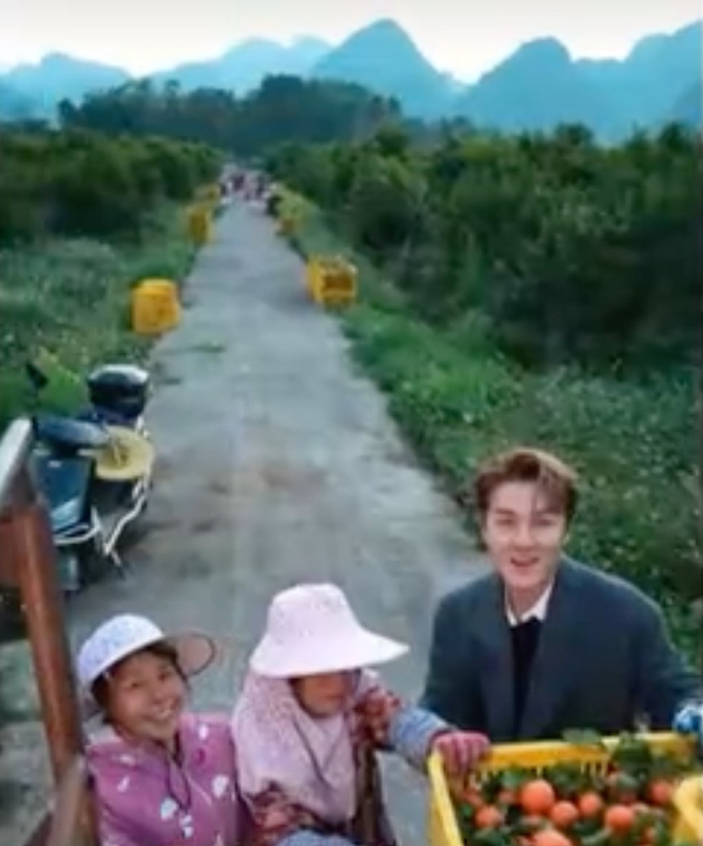 Wu, paling kanan, tampak bersama dua petani perempuan saat mereka mengangkut hasil panen mereka. Foto: CCTV