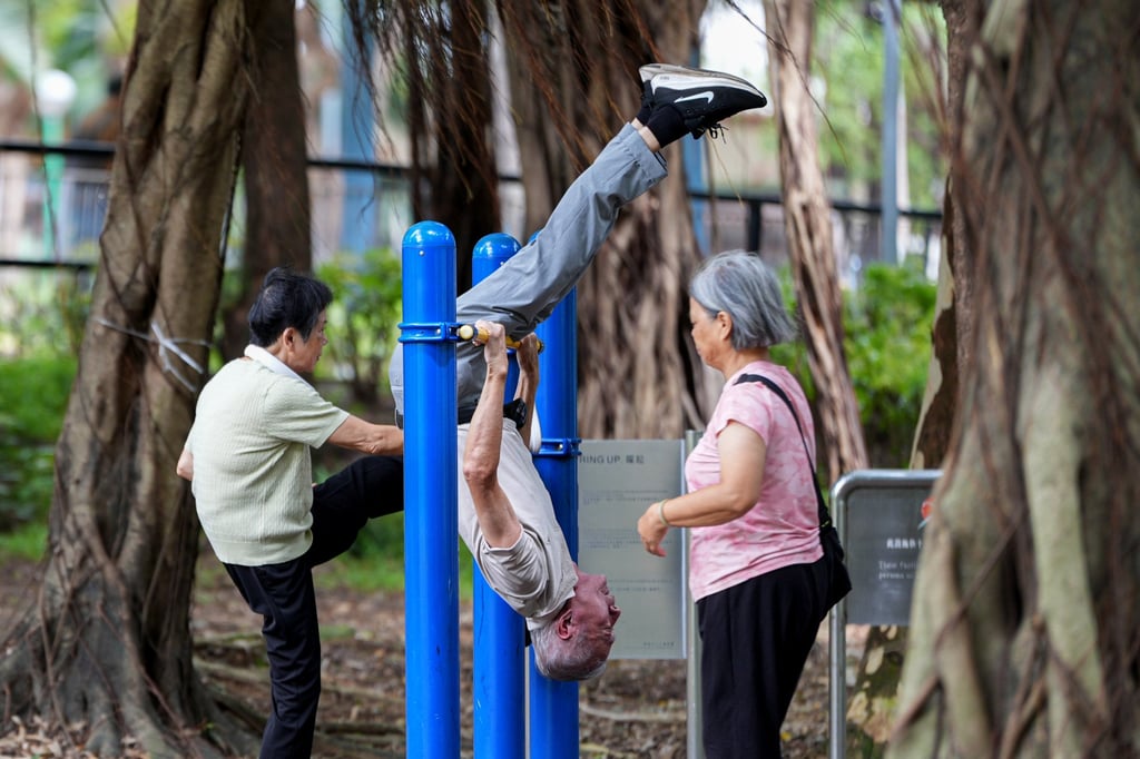 An elderly man hangs upside down on a horizontal bar during his morning exercise in Fanling on August 17, 2025. Photo: Eugene Lee