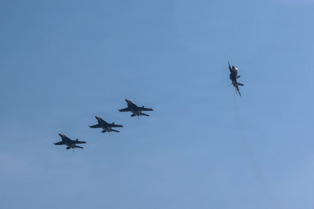 F/A-18E Super Hornets fly above the USS Abraham Lincoln. Photo: US Navy via AFP