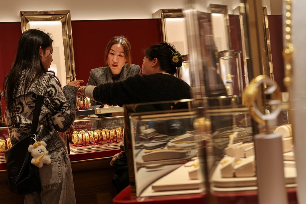 A customer tries a gold bracelet at a jewellery store in Hong Kong. Photo: Reuters A customer tries a gold bracelet at a jewellery store in Hong Kong. Photo: Reuters