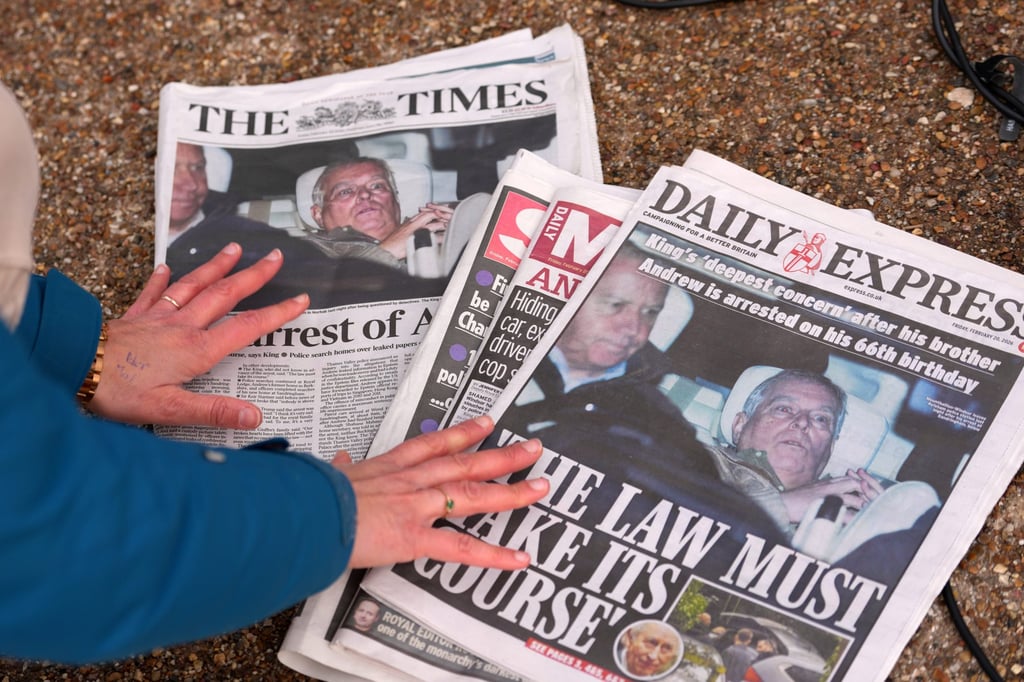 A journalist looks at Friday’s newspaper front pages in London. Photo: AP