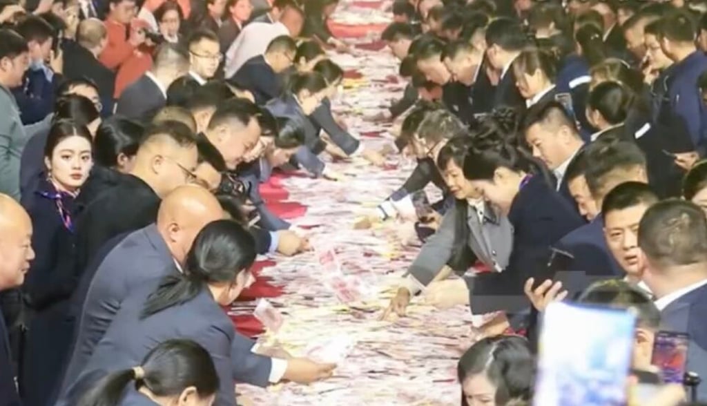 The company event saw rows of tables laid out which were covered with cash. Photo: Elephant News