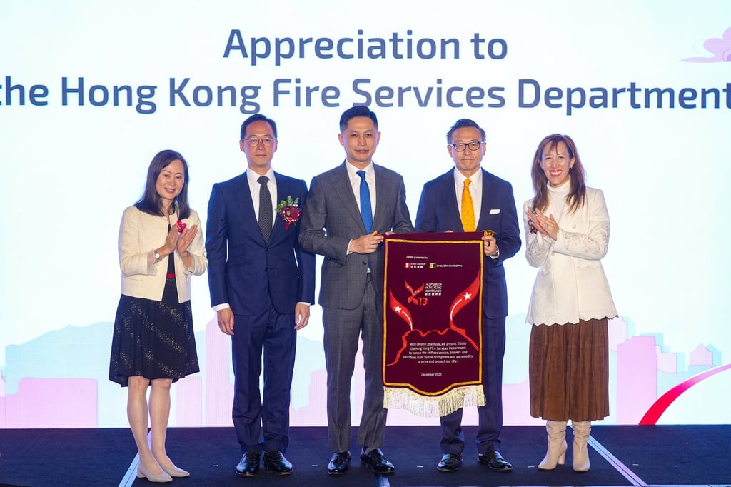 Alibaba’s Joe Tsai (second right) and fire services chief Andy Yeung hold the appreciation flag on stage, alongside the SCMP’s Tammy Tam (left), Ocean Park’s Paolo Pong (second left) and Sino Group’s Nikki Ng. Photo: Eugene Lee