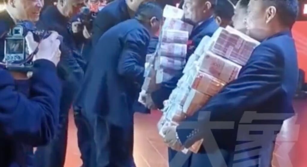 Company employees pictured carrying stacks of cash to be distributed. Photo: Elephant News Company employees pictured carrying stacks of cash to be distributed. Photo: Elephant News