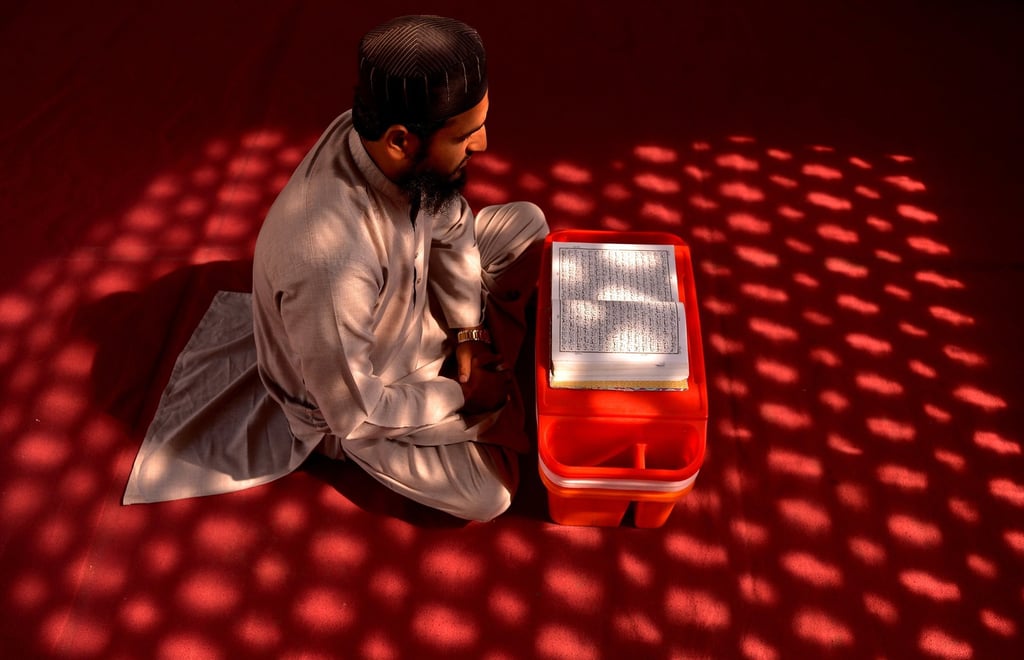 A man reads from a copy of the Muslims’ holy book, the Koran, at a mosque during the fasting month of Ramadan, in Peshawar, Pakistan, on Saturday. Photo: EPA