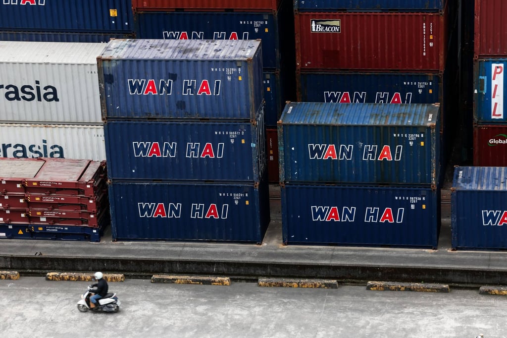 A man rides a scooter past shipping containers at the port in Keelung, Taiwan, on January 16. Photo: AFP