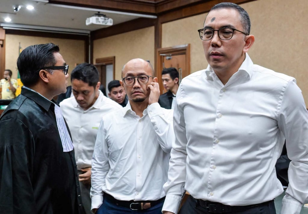 Yoki Firnandi (right), Sani Dinar Saifuddin (centre) and Agus Purwono speak to their lawyers following the sentencing hearing on Thursday. Photo: AFP