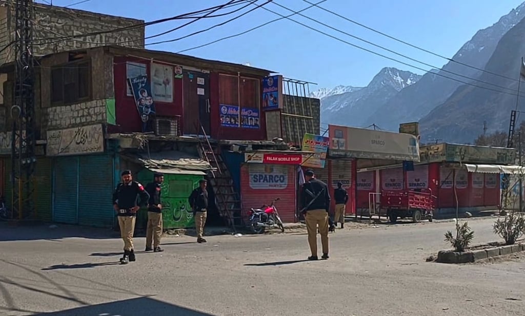 Police officers stand guard on a road after authorities impose curfew in Gigit, northern Pakistan, on Monday. Photo: AP