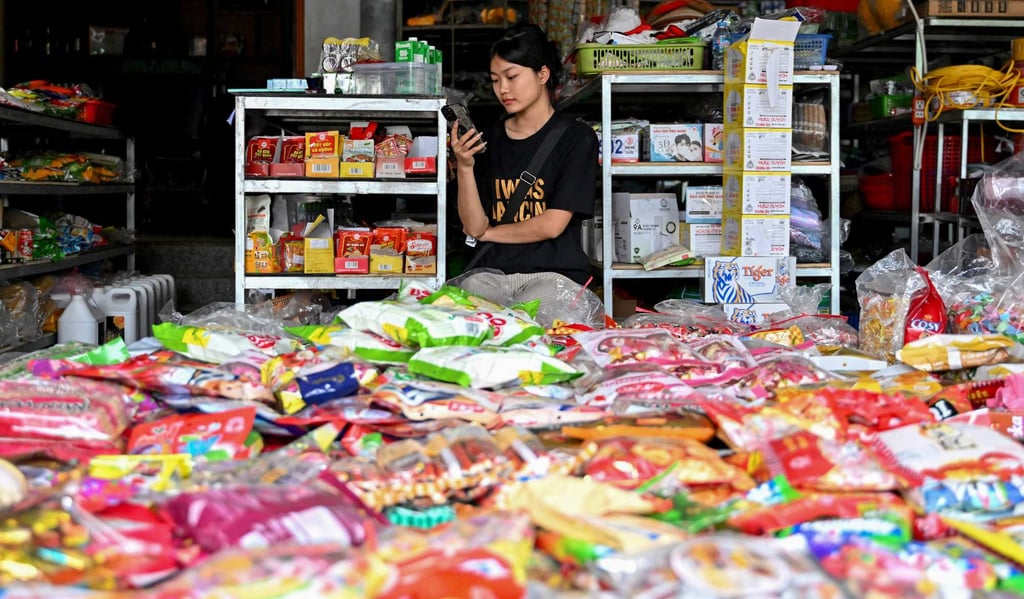 A Vietnamese shopkeeper uses her phone while waiting for customers at a grocery store in Hanoi on February 27. Photo: AFP A Vietnamese shopkeeper uses her phone while waiting for customers at a grocery store in Hanoi on February 27. Photo: AFP