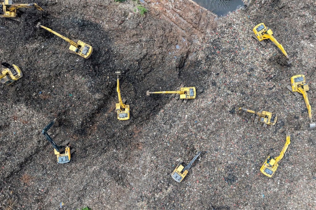 This aerial picture shows a rescue team using heavy machinery to search for missing people following a landslide at a rubbish dump in Indonesia. Photo: AFP This aerial picture shows a rescue team using heavy machinery to search for missing people following a landslide at a rubbish dump in Indonesia. Photo: AFP