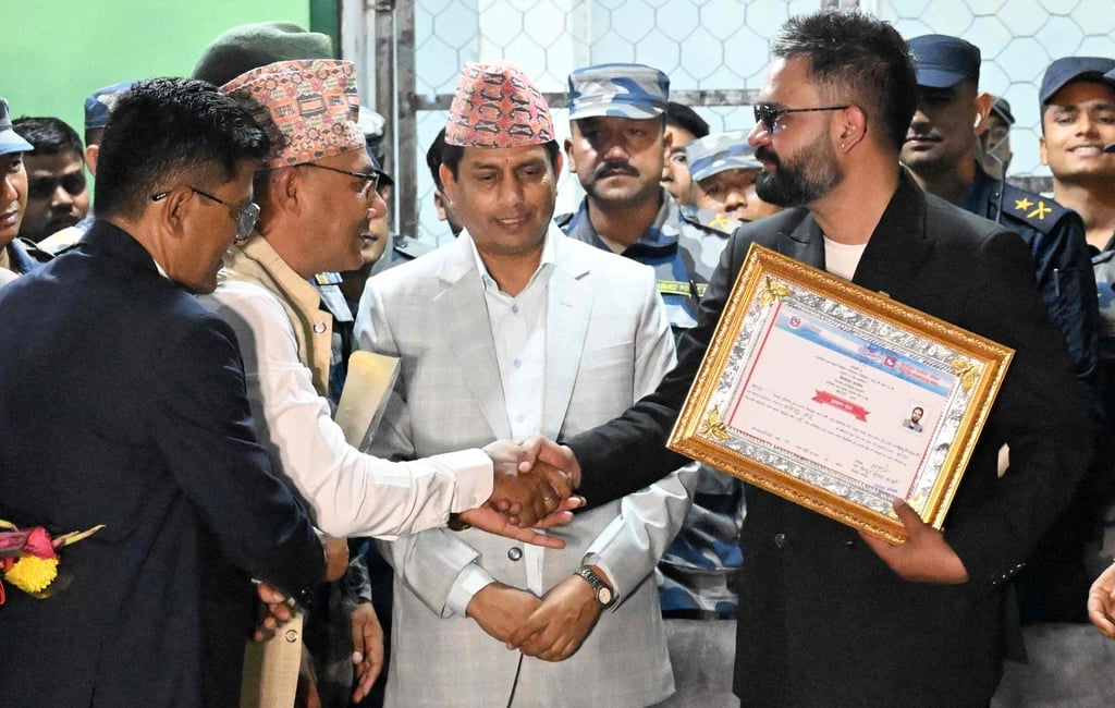 Balendra Shah shakes hands with supporters after collecting a certificate for his victory in the election on March 7. Photo: AFP