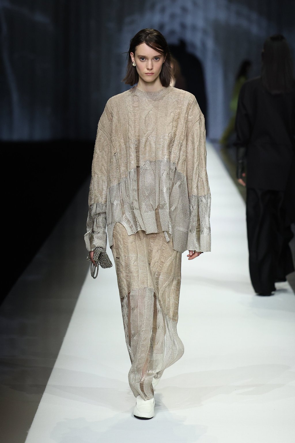 An oversized cable-knit sweater with deliberately frayed edges is paired with near-transparent knit trousers at Anteprima, giving form to Aiko Miyanaga’s exploration of the invisible. Photo: Getty Images