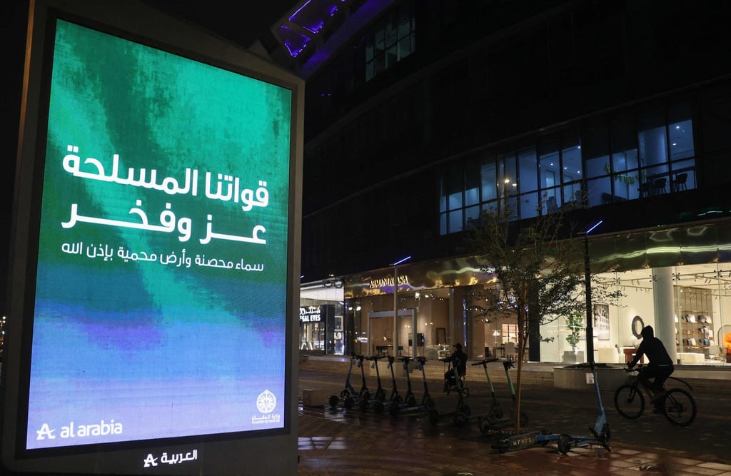 A man cycles past an electronic board reading “Our Armed Forces are our pride and honour. A fortified sky and a protected land, by the will of God.” in the Saudi capital of Riyadh on Tuesday. Photo: AFP