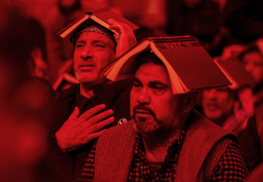 Shiite worshippers place copies of the Quran on their heads during Laylat al-Qadr, the Night of Destiny, at the Imam Ali shrine in Najaf, Iraq, on Tuesday. Photo: AP