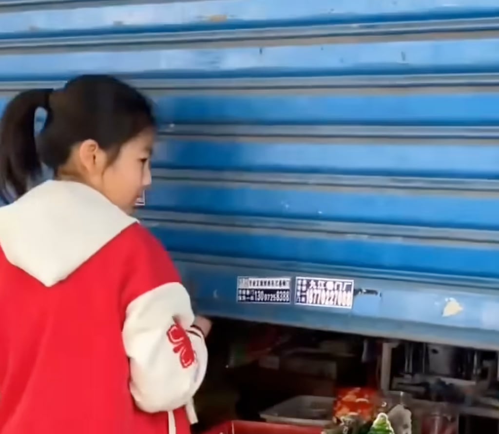 Li Yue pulls up the shutters of her shop at the start of another busy day. Photo: YouTube