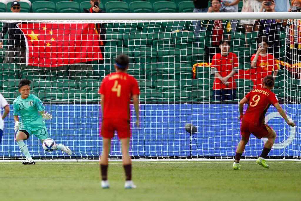 Chinese Taipei keeper Cheng Ssu-yu (left) saves a penalty by China’s Wurigumula (right). Photo: AP