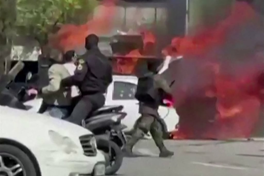 A video grab taken from social media on Tuesday shows a vehicle from Iran’s special police unit ablaze in Tehran’s Enqelab Square. Photo: UGC/AFP