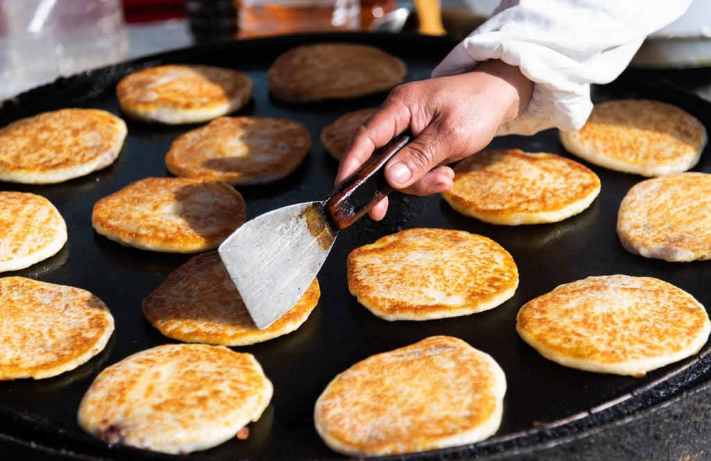 Pancake ala Tiongkok modern ini sedang dimasak di sebuah warung penjual makanan di pinggir jalan. Foto: Shutterstock