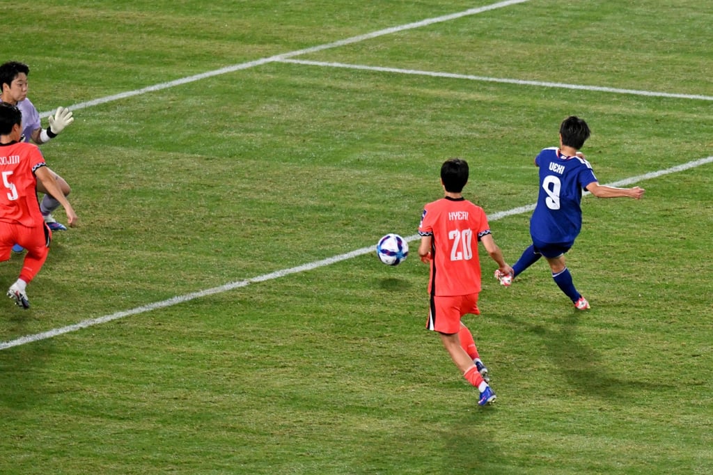 Japan's Riko Ueki (right) scores his team's first goal against South Korea. Photo: AFP