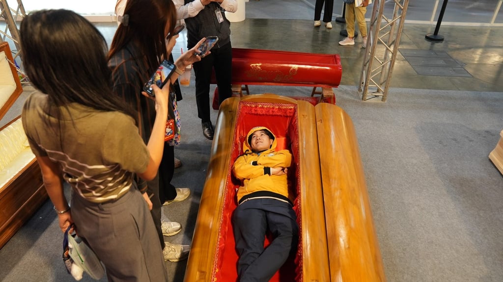 A visitor tries out a coffin at Death Fest in Nonthaburi, Thailand. Photo: Aidan Jones