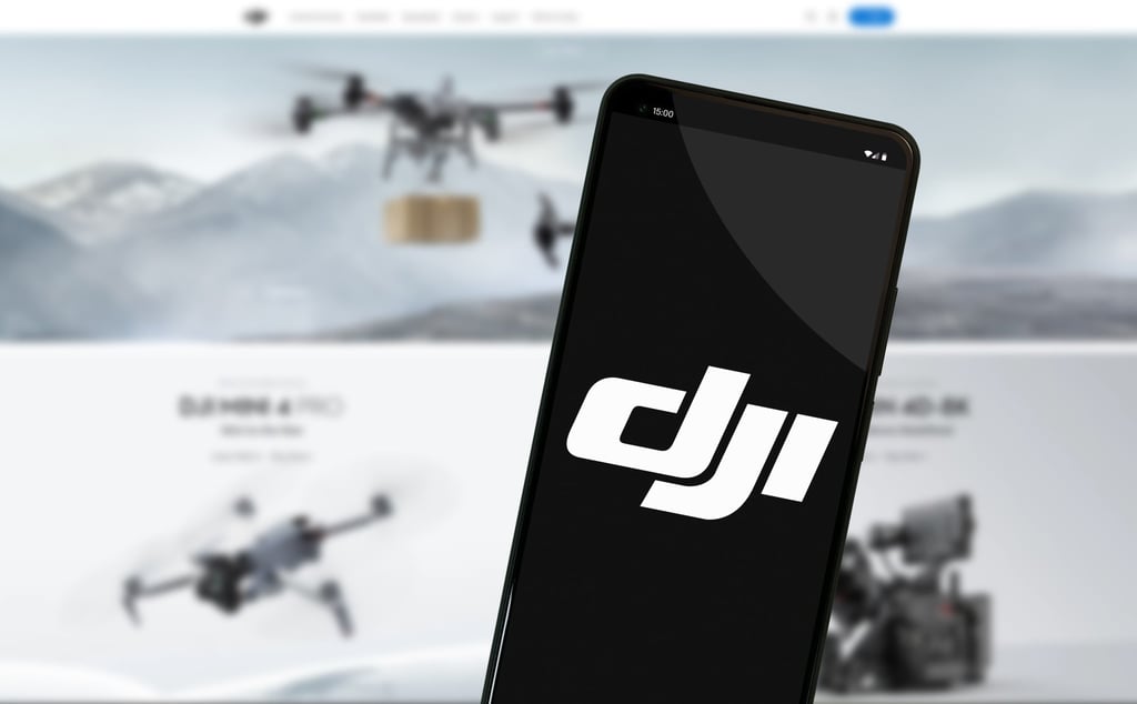 The DJI logo is seen on a mobile phone screen in front of the company’s website. Photo: Shutterstock Images The DJI logo is seen on a mobile phone screen in front of the company’s website. Photo: Shutterstock Images