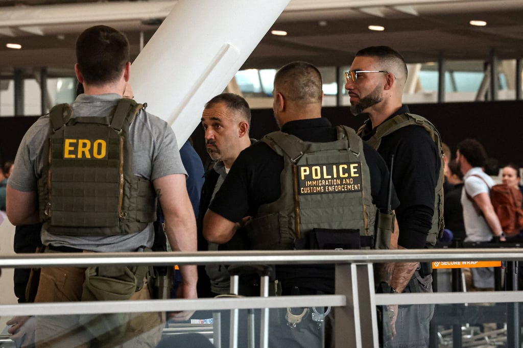 An ICE agent watches the TSA security line at New York's John F. Kennedy International Airport on Thursday. Photo: Reuters An ICE agent watches the TSA security line at New York's John F. Kennedy International Airport on Thursday. Photo: Reuters