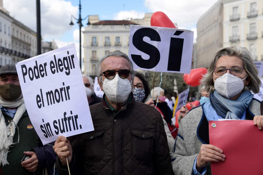 A man holds a placard reading “To choose to die without suffering” during a demonstration in support of a law legalising euthanasia in Madrid in March 2021. Photo: AFP
