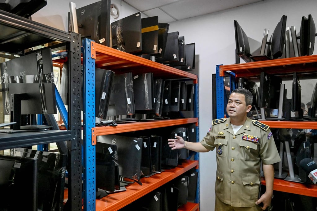 A Cambodian military official shows computer equipment seized from raided cyberscam centres on March 11. Photo: AFP A Cambodian military official shows computer equipment seized from raided cyberscam centres on March 11. Photo: AFP