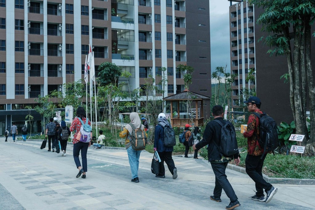 Civil servants walking to their flats after arriving by shuttle bus in Ibu Kota Nusantara (IKN), the planned new capital of Indonesia in East Kalimantan. Photo: AFP