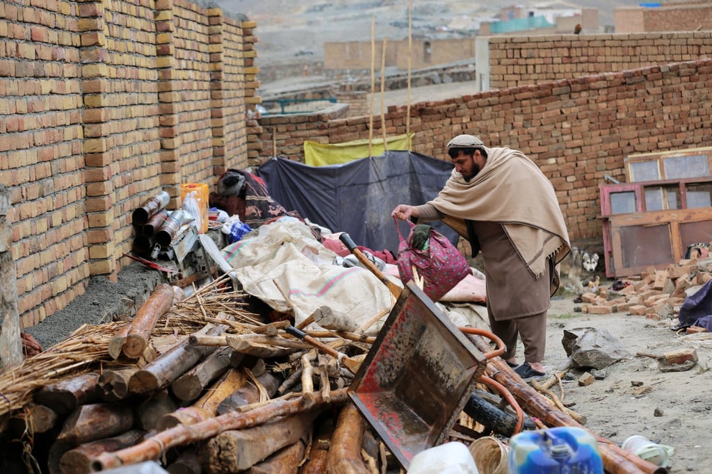Mohibullah Niazi, who tried to help save a family in an earthquake on Friday, searches through items piled up at a damaged house in the village of Ittefaq, on the outskirts of Kabul. Photo: AP