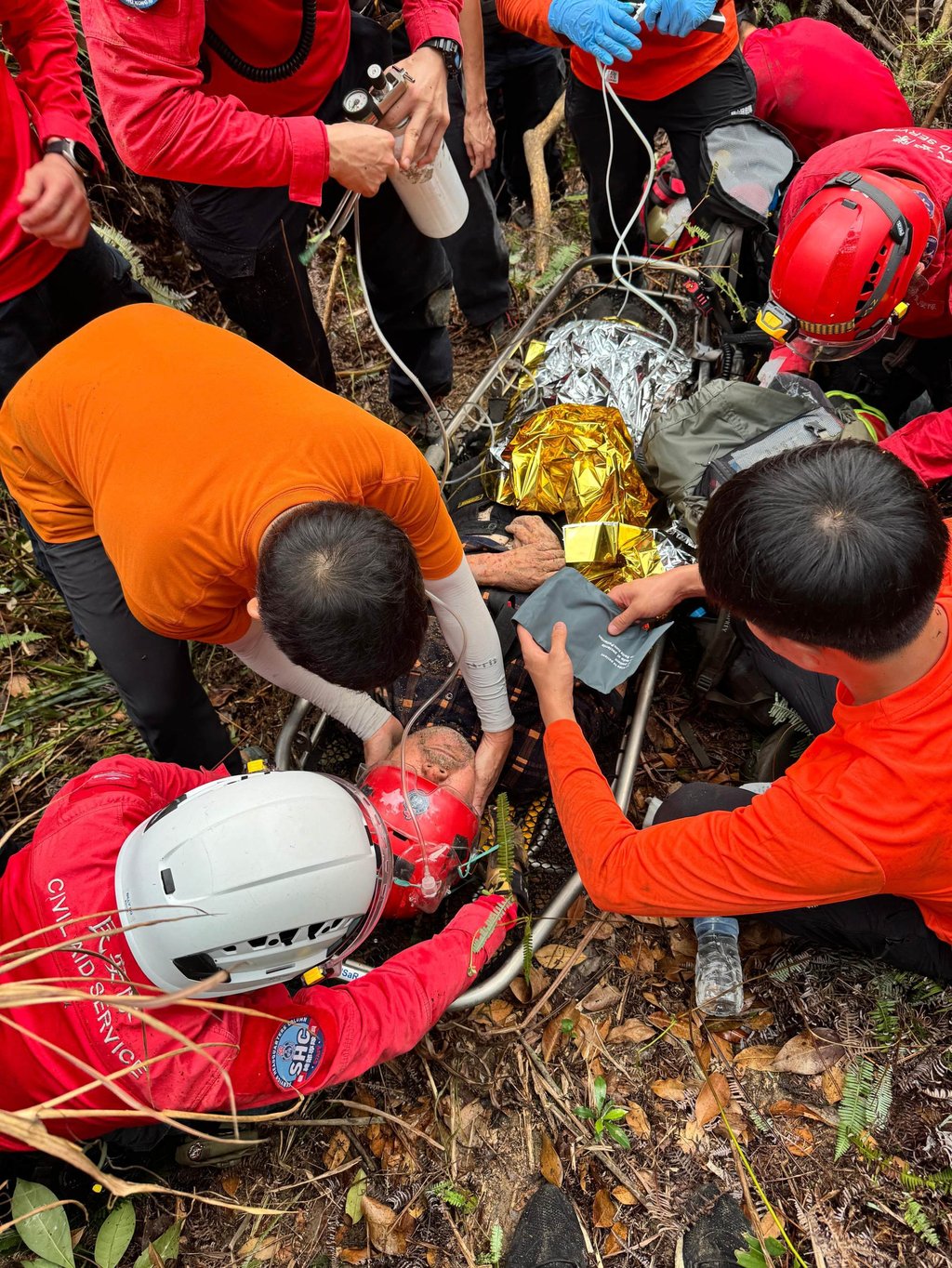 The rescue team attends to the 79-year-old hiker before airlifting him to hospital. Photo: Handout The rescue team attends to the 79-year-old hiker before airlifting him to hospital. Photo: Handout