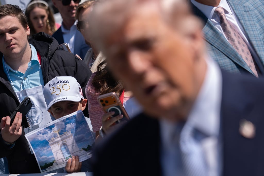 A boy holds up a rendering of an arch US President Donald Trump proposed building in Washington on Monday. Photo: AP