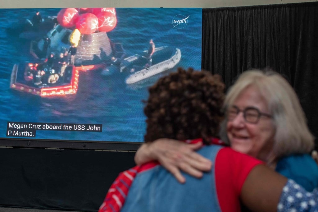People hug as they watch a live broadcast of the return of the Artemis II crew members to Earth in San Diego, California, on Friday. Photo: AFP