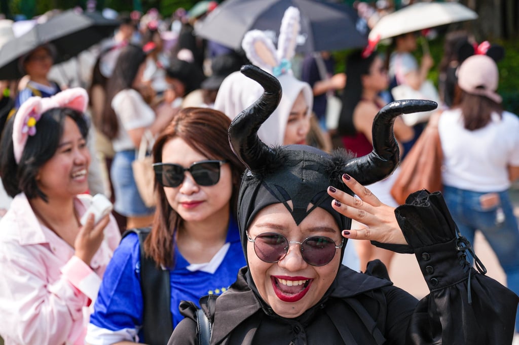 Novita Herdiana (centre) and friends take a picture at the park’s entrance of Hong Kong Disneyland. Photo: Eugene Lee