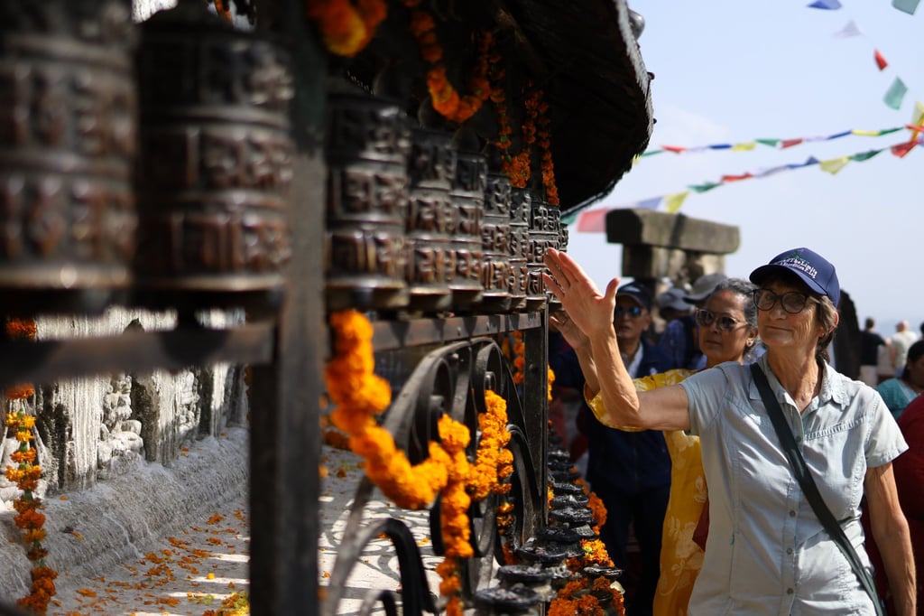 A tourist spins the prayer wheels while circumnavigating the Swayambhunath Stupa, a Unesco World Heritage site in Kathmandu. Photo: Getty Images