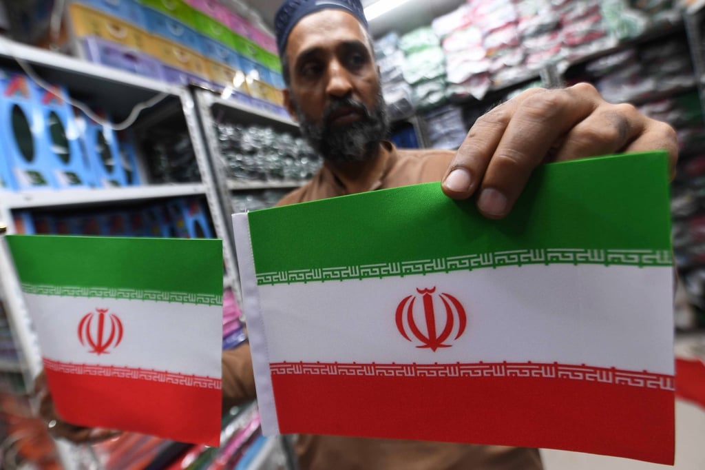 A shopkeeper displays Iranian flags after the US-Iran ceasefire announcement in Karachi, Pakistan. Photo: EPA