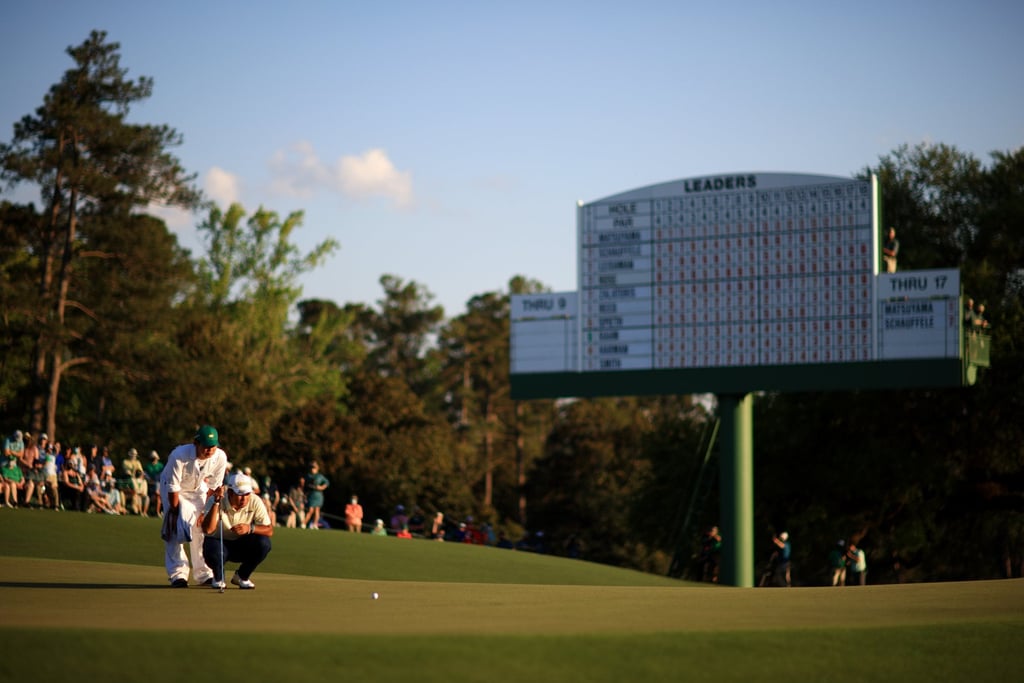 Hideki Matsuyama and his caddie line-up a putt at the Masters. Photo: Handout