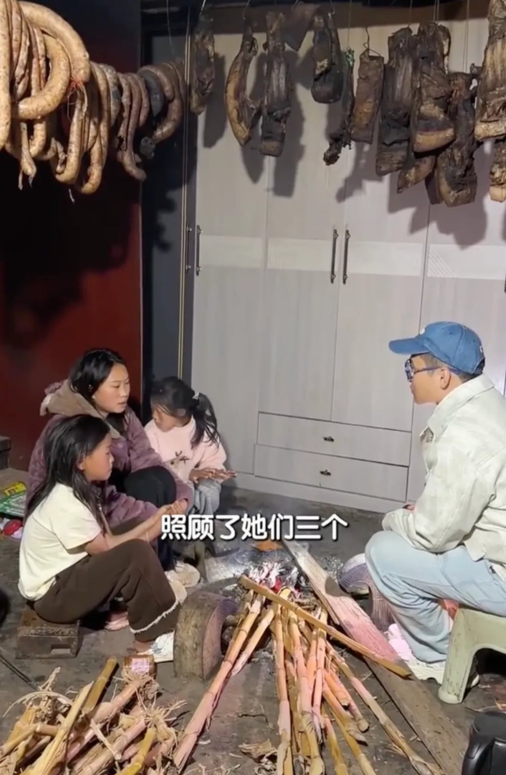 Chen Jiajun, right, chats with Aji and her sisters as they sit around a rudimentary fire. Photo: Weibo