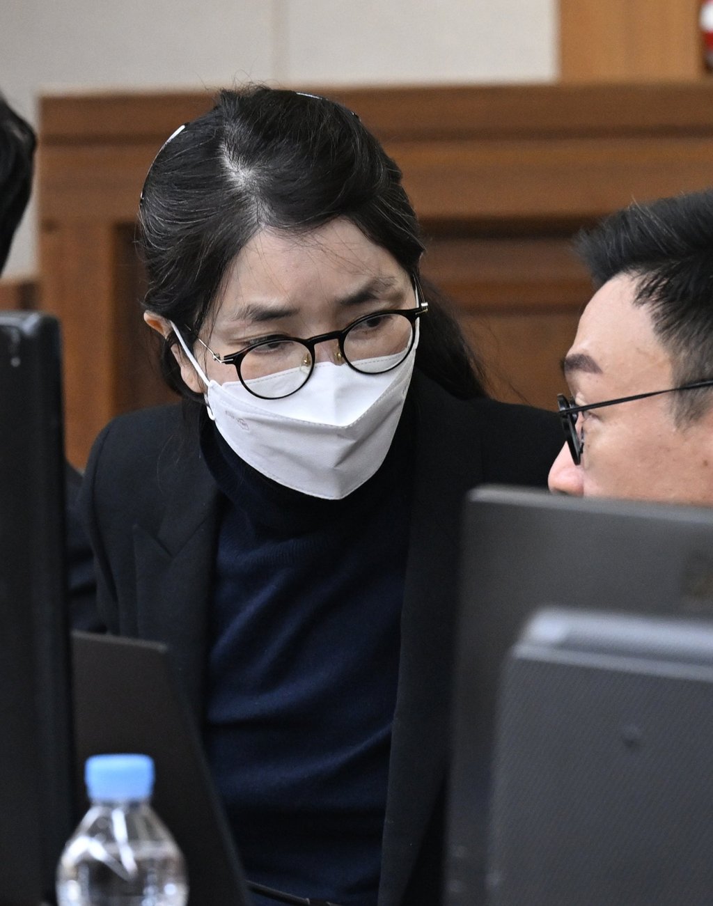 Kim Keon-hee, wearing a face mask, talks with her lawyer at the Seoul Central District Court in December. Photo: Yonhap/EPA