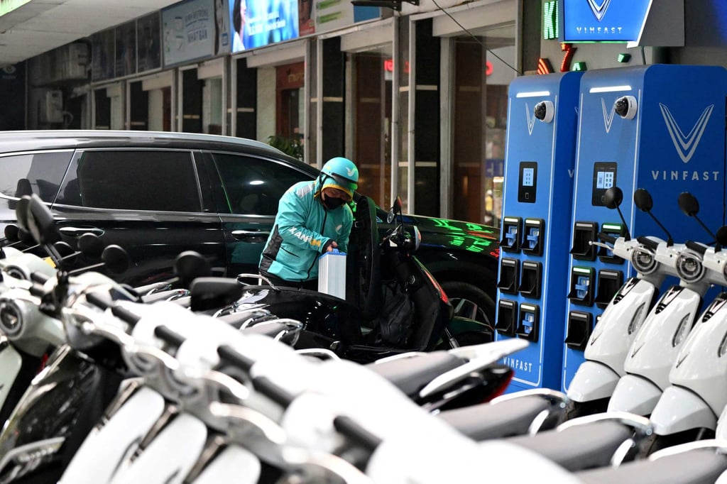 A rider swaps batteries at a VinFast station in Hanoi on April 11. Electric vehicle sales have jumped in Vietnam as buyers try to dodge the fuel price spikes driven by the Middle East war – and the US’ foreign policy. Photo: AFP