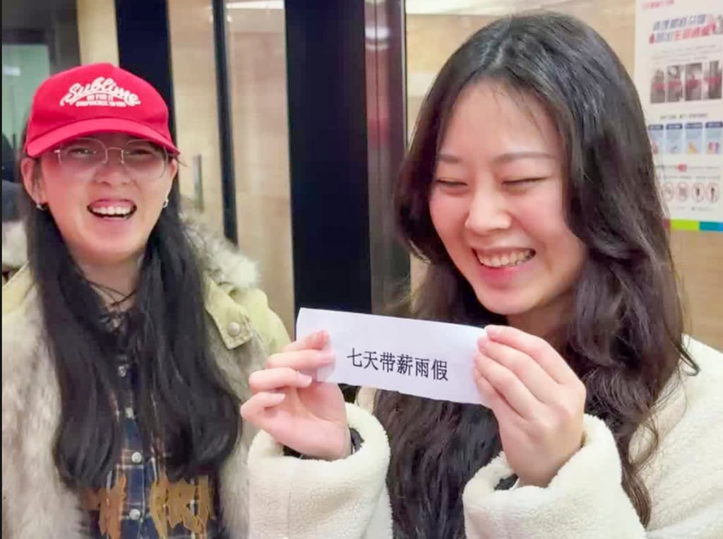 The lucky woman on the right was all smiles when she won her rain leave raffle prize. Photo: Sohu