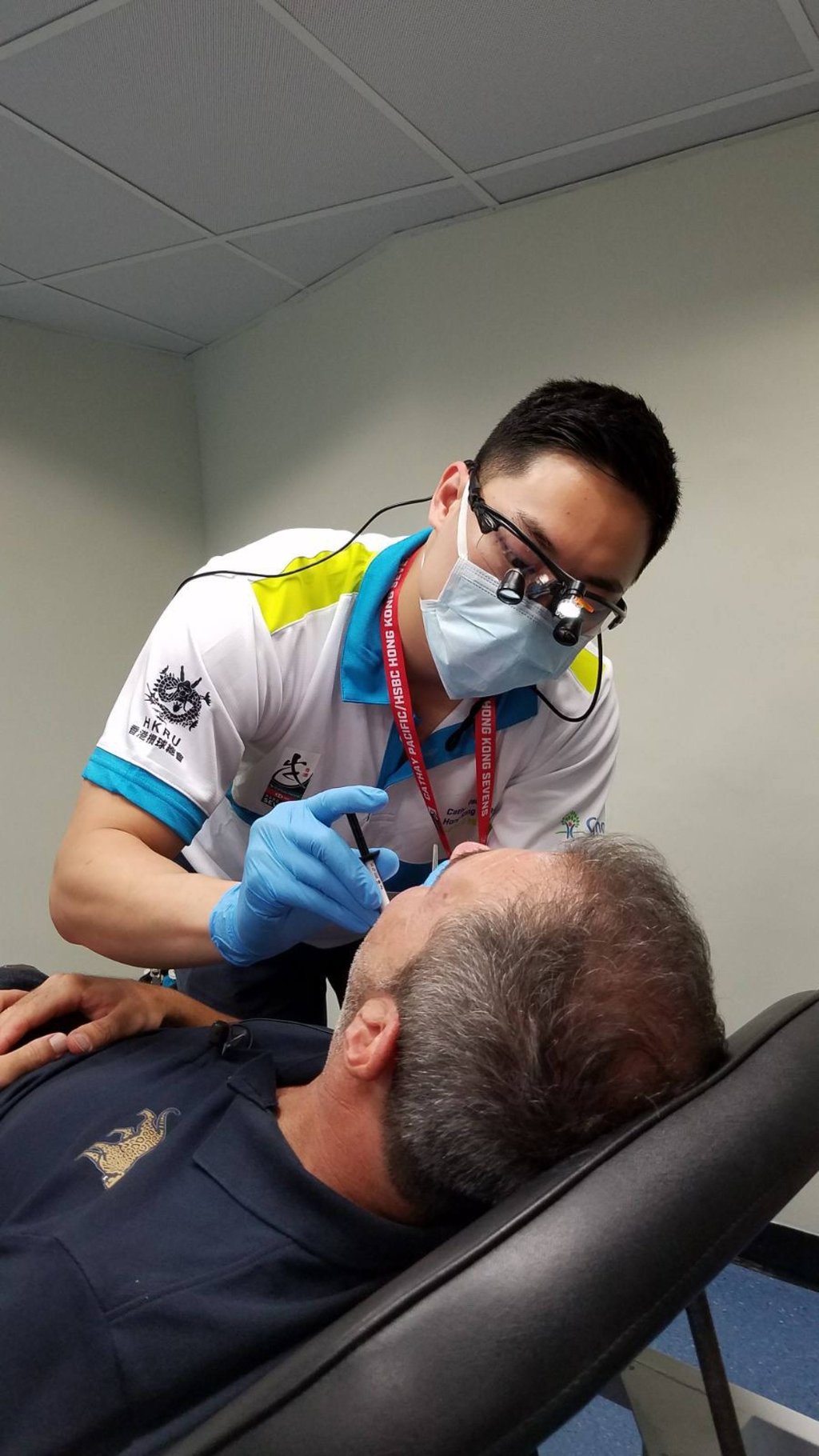 Eugene Cheung repairing a broken tooth of the Zimbabwean coach in his first year as a tournament dentist. Photo: Eugene Cheung